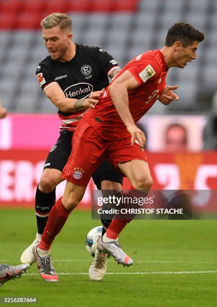 Bayern Munich's Polish forward Robert Lewandowski and Fortuna Duesseldorf's German defender Andre Hoffmann vie for the ball during the German first...