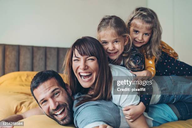 mor, far och tvillingflickor staplade ovanpå varandra - family portrait humor bildbanksfoton och bilder