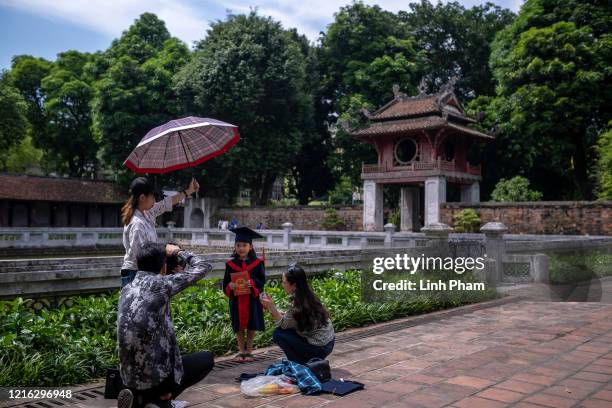 Pupil has her kindergarten graduation photo taken at Temple of Literature, a popular destination amongst both locals and tourists, on May 31, 2020 in...