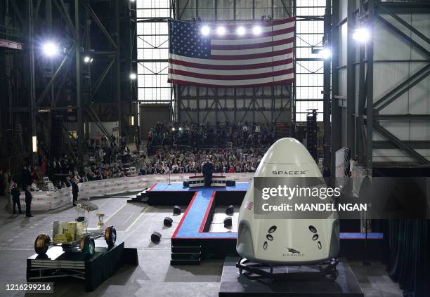 President Donald Trump speaks near a SpaceX Crew Dragon capsule at a press briefing after the launch of the SpaceX Falcon 9 rocket and Crew Dragon...