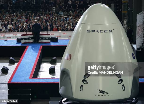President Donald Trump speaks near a SpaceX Crew Dragon capsule at a press briefing after the launch of the SpaceX Falcon 9 rocket and Crew Dragon...