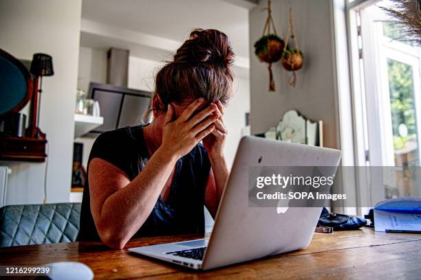 In this photo illustration a woman appears to be stressed as she searches for a job online during the coronavirus economic recession. The global...