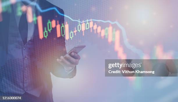 coronavirus impact global economy stock markets financial crisis concept,the coronavirus or covid-19 sinks the global stock exchanges. smartphone app showing the collapse of the stock market of virus - impact investing stock pictures, royalty-free photos & images