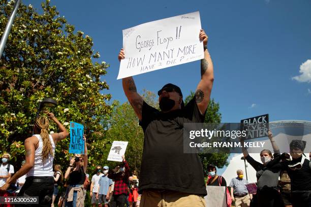 People gather at city hall during a racial justice protest in Charlottesville on May 30, 2020. - Demonstrations are being held across the US after...