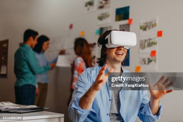 man using virtual reality glasses in design office studio next by coworkers - user experience stock pictures, royalty-free photos & images