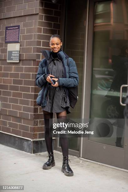 Model Aaliyah Hydes wears a blue puffer jacket, black and gray striped dress, tights, black boots after the Self-Portrait show on February 08, 2020...