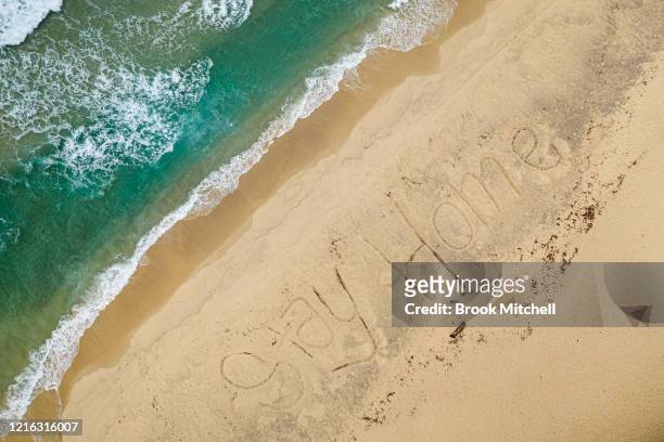 An aerial view of Bronte Beach with the words #StayHome written into the sand by local lifeguards on April 02, 2020 in Sydney, Australia. The...