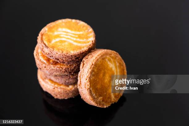 homemade cookies, bretagne sables, galette bretonne, stacked tower isolated on black background - biscotte stock-fotos und bilder