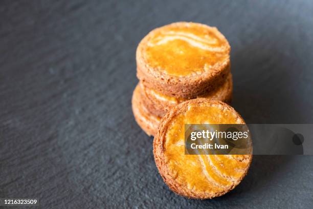 homemade cookies, bretagne sables, galette bretonne, stacked tower isolated on black background - biscuit france stock pictures, royalty-free photos & images