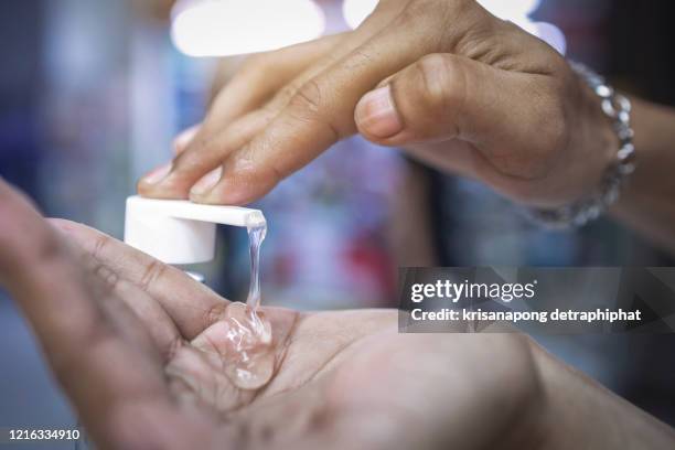 male hands using hand sanitizer gel pump dispenser,hand wash gel - squirt foto e immagini stock