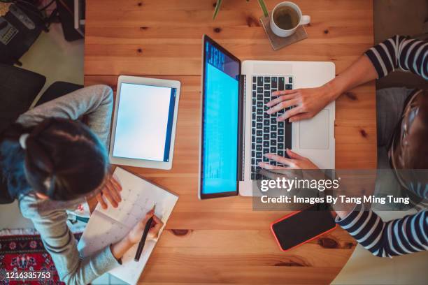 direct above view of mom & daughter using laptop computer & tablet in workspace at home - covid-19 business meeting stock pictures, royalty-free photos & images