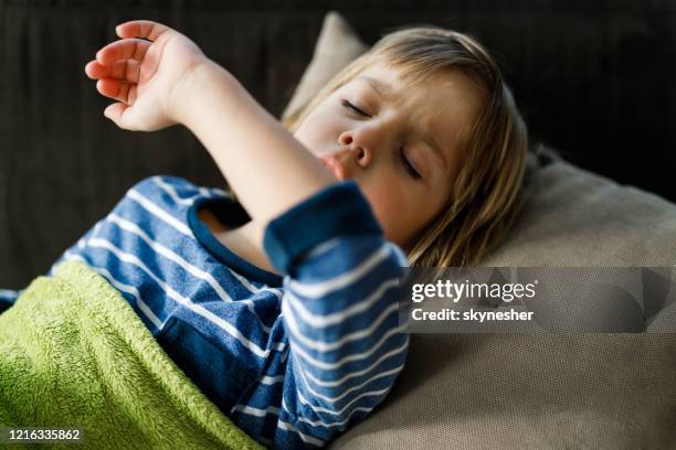 ill little boy husten, während im bett zu hause ruhen. - cough stock-fotos und bilder