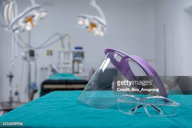 group of protective headwear for doctor and nurse (such as face shield and safety glasses) before surgery in operating room. - face shield ストックフォトと画像