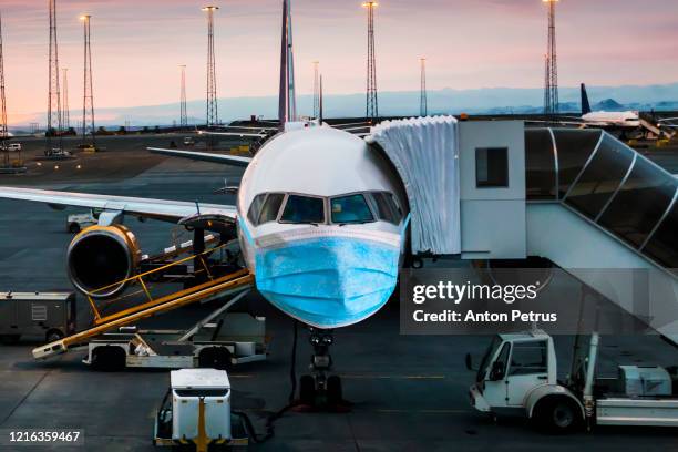 airplane in a medical mask. air travel crisis concept - air pollution mask stockfoto's en -beelden