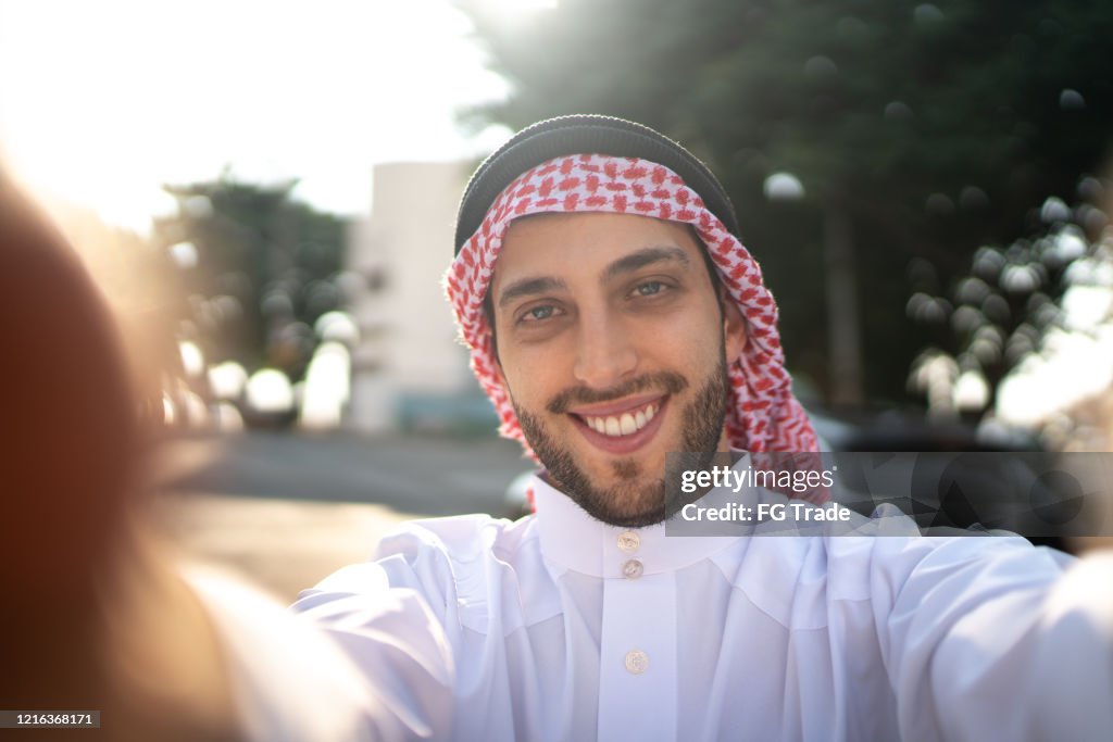 Homem árabe do Oriente Médio tirando uma selfie na rua