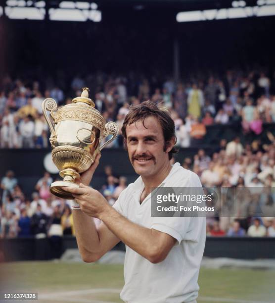 John Newcombe of Australia holds aloft the Gentlemen's Singles Championship Trophy after defeating Stan Smith of the United States, 6-3, 5-7, 2-6,...