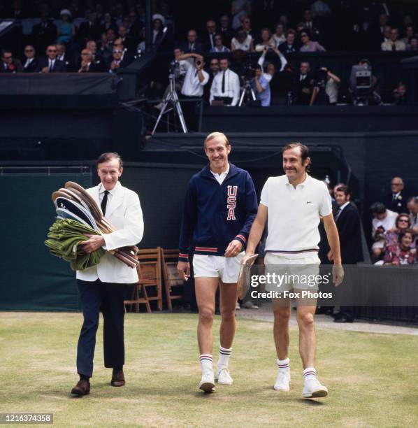 John Newcombe of Australia and Stan Smith of the United States walk out onto the Centre Court with Leo Turner the locker room attendant carrying...