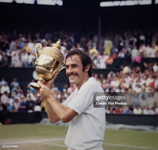 John Newcombe of Australia holds aloft the Gentlemen's Singles Championship Trophy after defeating Stan Smith of the United States, 6-3, 5-7, 2-6,...