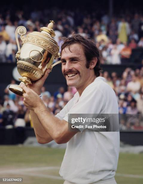 John Newcombe of Australia holds aloft the Gentlemen's Singles Championship Trophy after defeating Stan Smith of the United States, 6"u20133,...