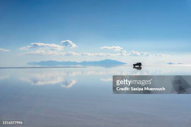reflection of the cloud and an off-road car, uyuni salt flat, bolivia - salar de uyuni stockfoto's en -beelden