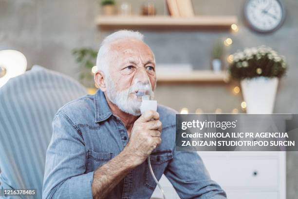 senior inhalation therapy in progress during pandemic covid-19 . corona virus. - inhaling smoke stock pictures, royalty-free photos & images