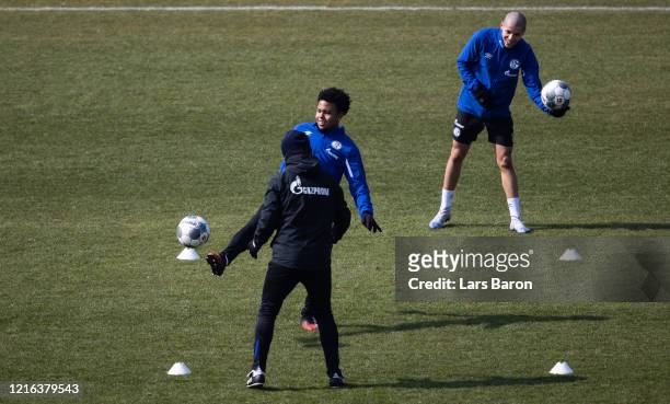 Weston McKennie kicks the ball next to Amine Harit during a training session at FC Schalke 04 training ground on April 02, 2020 in Gelsenkirchen,...
