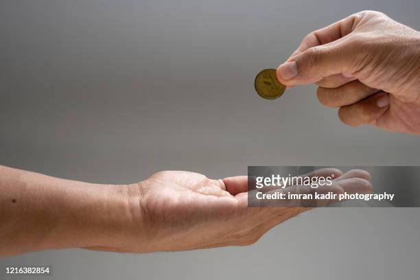 donation or zakat, hand giving money for helping on close up shot. - money donation stock pictures, royalty-free photos & images