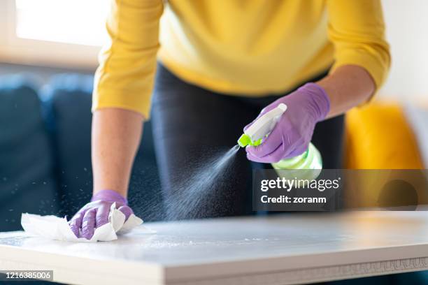 hands in gloves disinfecting coffee table - spray bottle stock pictures, royalty-free photos & images