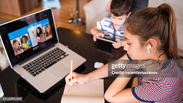 tiener die met video online les thuisfamilie in isolatie studeert homeschooling en afstandsonderwijs - ver stockfoto's en -beelden