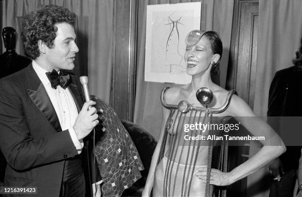 American columnist and publicist R Couri Hay interviews an unidentified model, dressed in repurposed bicycle parts ,during the 'Fashion as Fantasy'...