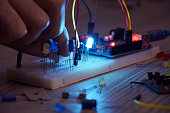 An engineer working on open-source hardware and software project, breadboard, electronic module