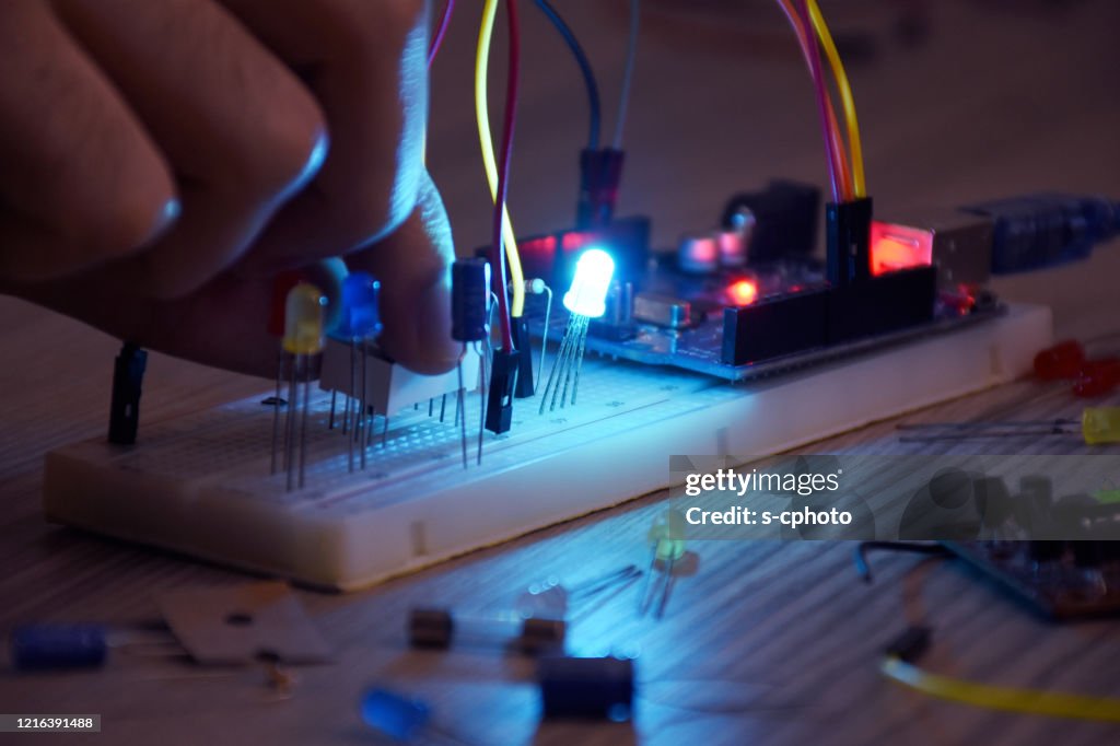 An engineer working on open-source hardware and software project, breadboard, electronic module