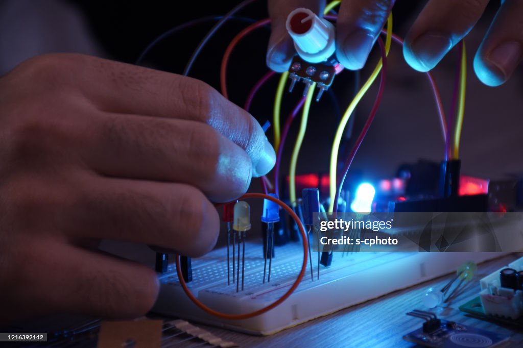 An engineer working on open-source hardware and software project, breadboard, electronic module