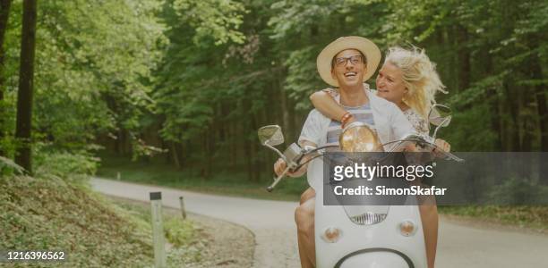 mature couple riding scooter together - couple scooter stock pictures, royalty-free photos & images