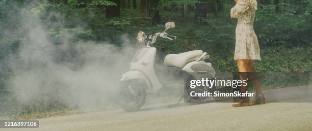 donna con un vestito con scooter bianco rotto nella foresta - motor scooter foto e immagini stock