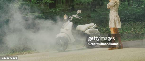 woman in a dress with broken down white scooter in the forest - motorcycle accident stock pictures, royalty-free photos & images