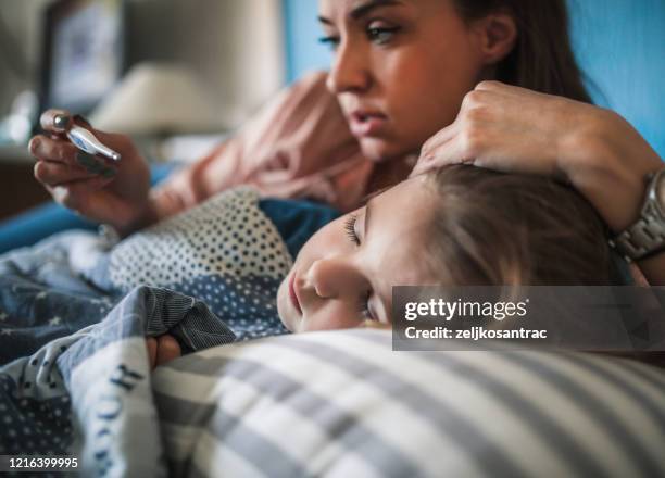 misurare la temperatura sul bambino malato covid -19 concetto - malattia foto e immagini stock