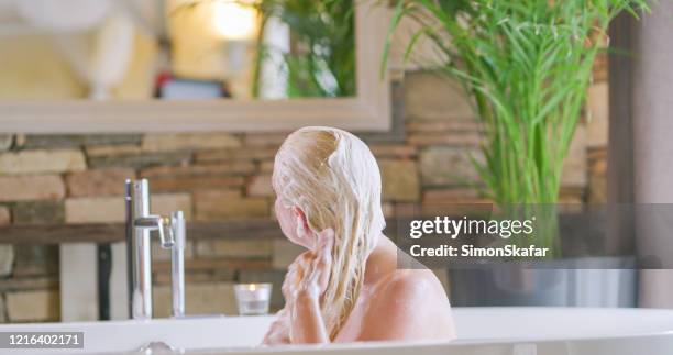 woman washing hair in bathtub - woman bath tub wet hair stock pictures, royalty-free photos & images