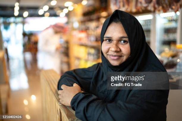portrait of arab middle east woman at her small business - qatar business stock pictures, royalty-free photos & images