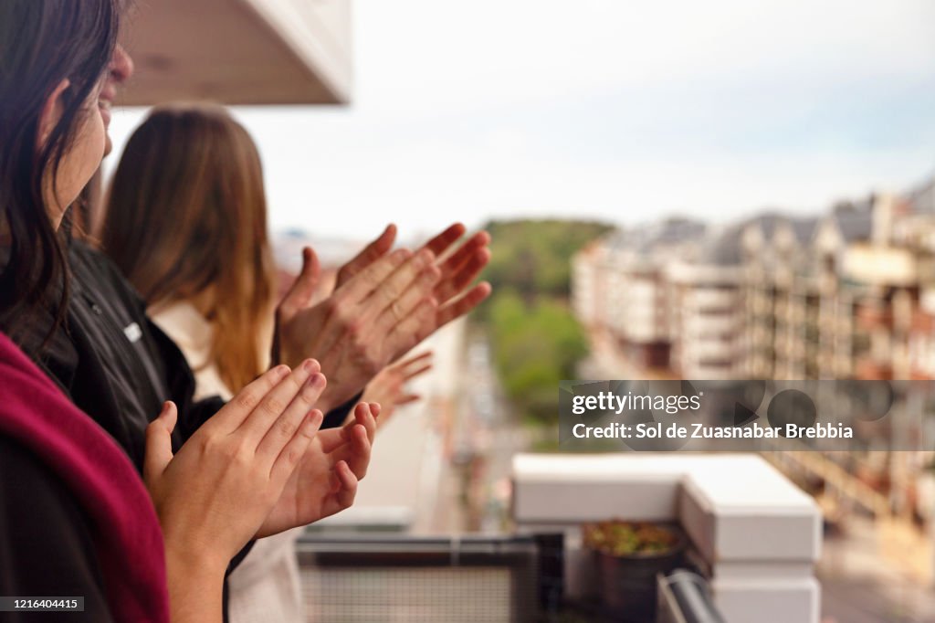 Family applauding from the balcony of their home