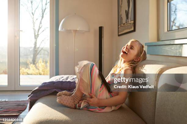 happy girl using digital tablet on sunny living room sofa - rapariga no quarto tecnologia imagens e fotografias de stock