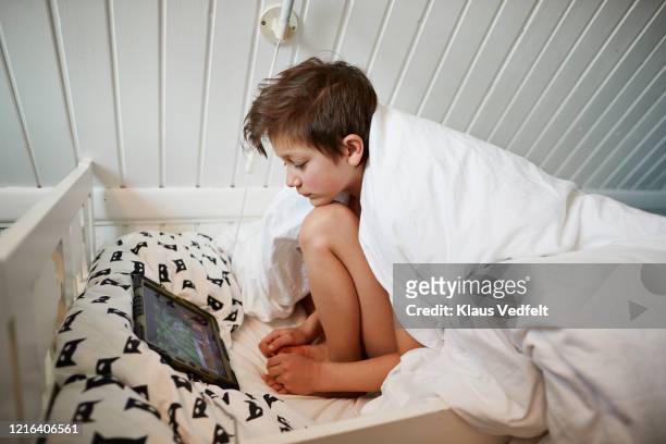 Boy using digital tablet in bed in the morning