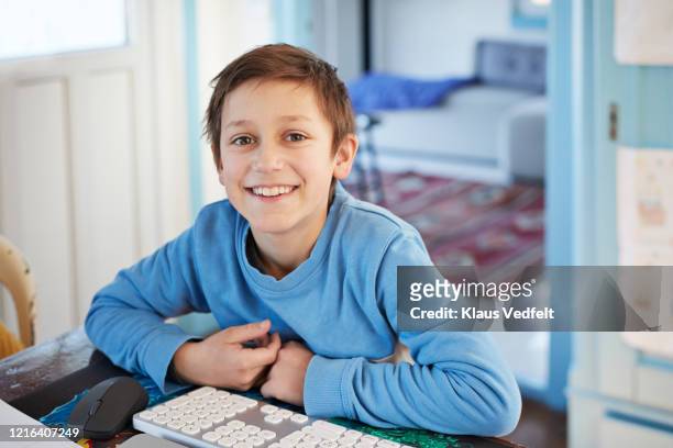 portrait smiling boy using computer at table - 8歳から9歳 ストックフォトと画像