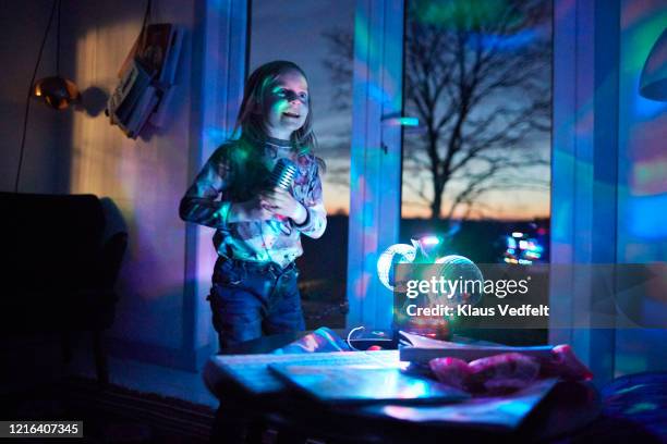 happy girl with microphone singing in living room with disco ball - copenhagen night stock pictures, royalty-free photos & images