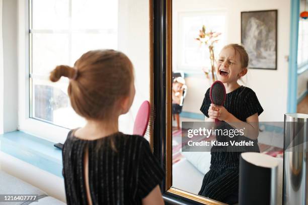 girl singing into hairbrush at mirror - girl singing imagens e fotografias de stock