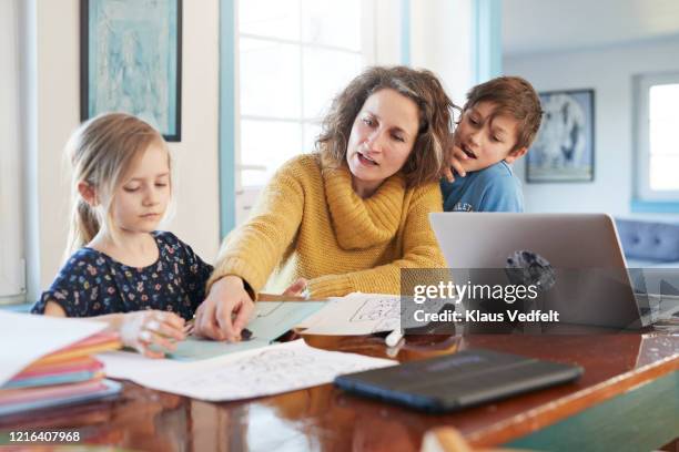 mother homeschooling daughter and son at dining table - homeschool 個照片及圖片檔