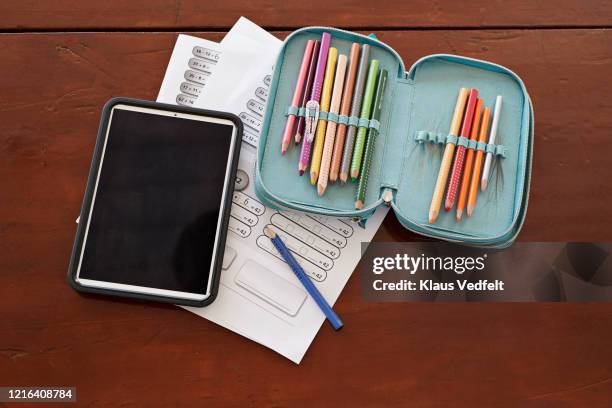 digital tablet, colored pencils and math homework on table - etui stockfoto's en -beelden