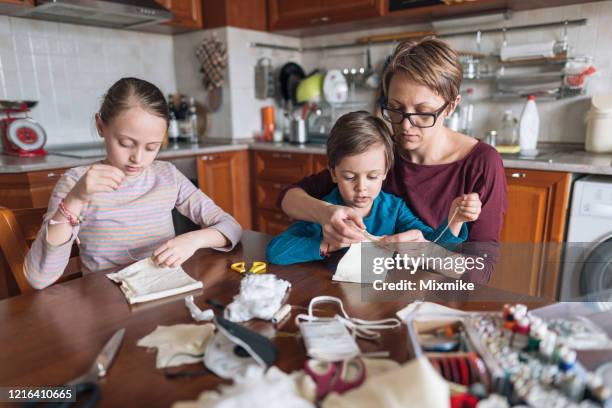 family hand sewing protective face masks - diy disaster stock pictures, royalty-free photos & images