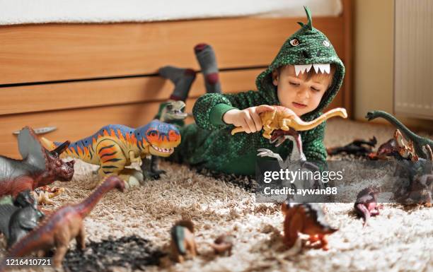 söt pojke leker med sina dinosaurier - dinosaurie bildbanksfoton och bilder