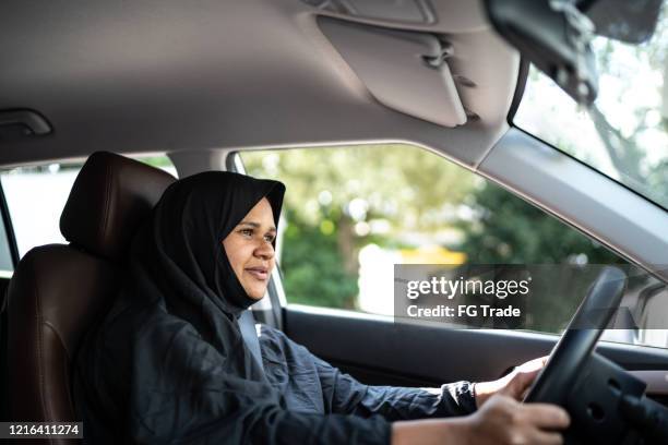 portret van een arabische vrouw van het midden-oosten die een auto drijft - arab woman driving stockfoto's en -beelden